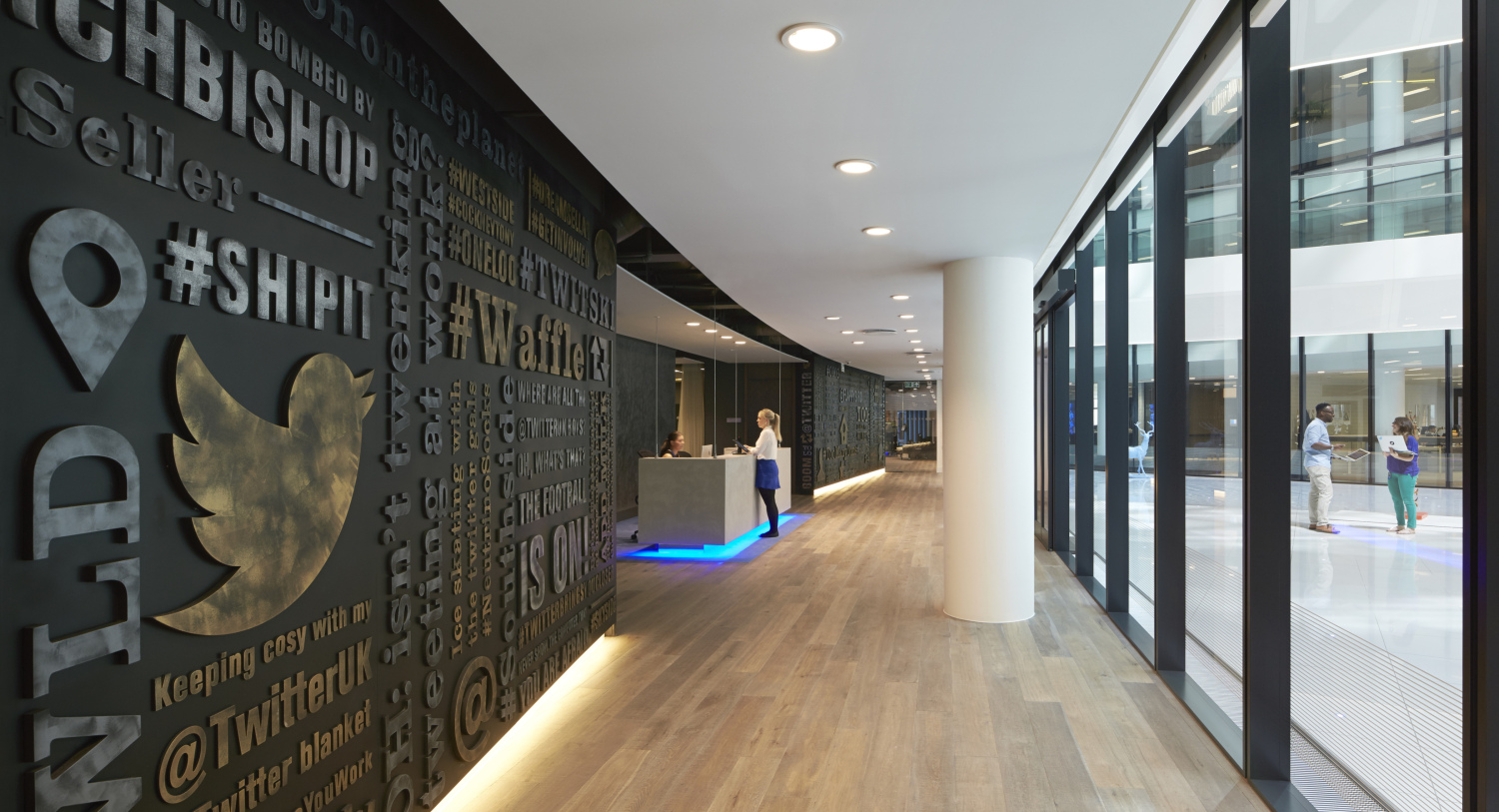 Wall with Twitter bird logo, reception desk beyond.