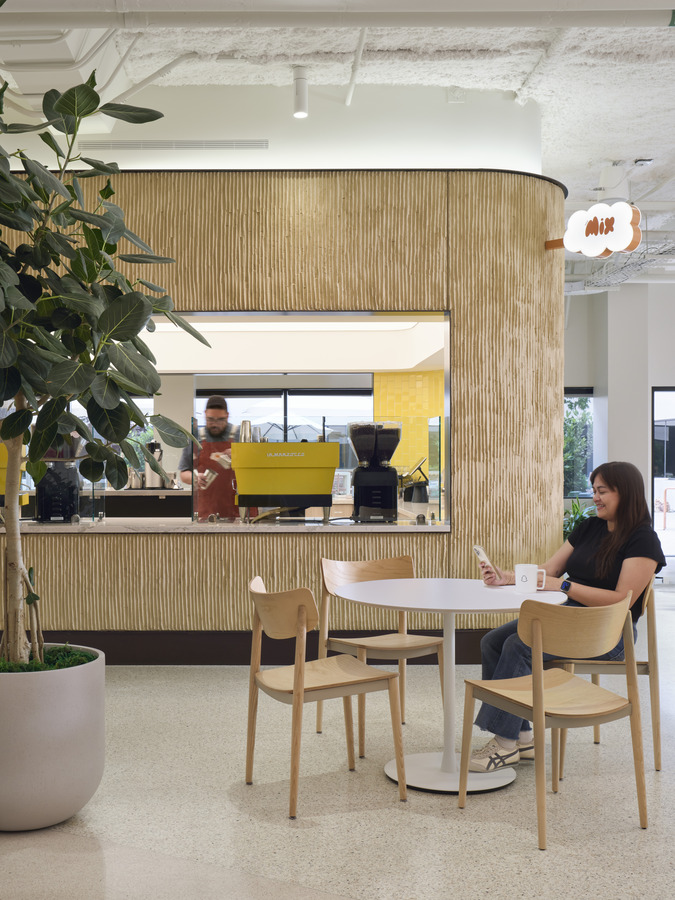 First floor social hub bringing together reception, coffee service, and collaborative work areas
