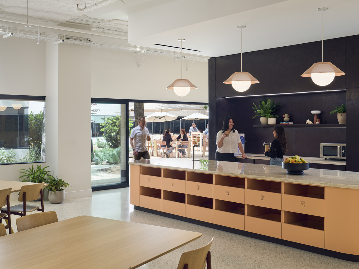 Café with hospitality-inspired finishes opening onto the active courtyard